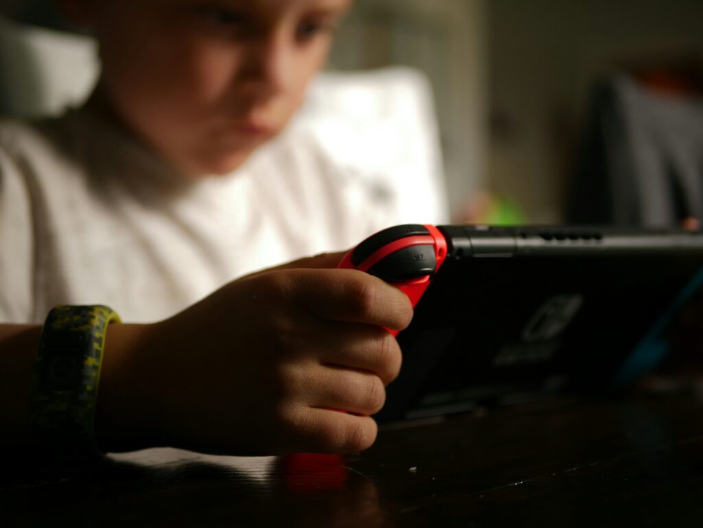 Niño jugando ala Nintendo Switch que le han regalado por su comunión