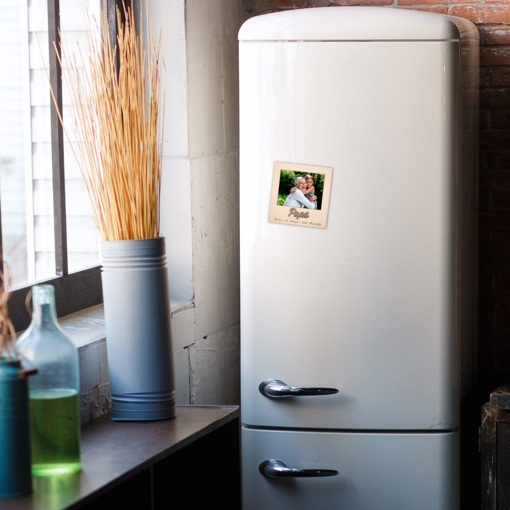 Kitchen interior in dark textured colors with white modern retro fridge, rustic brick wall, window and vase decor. Vertical still-life photo.